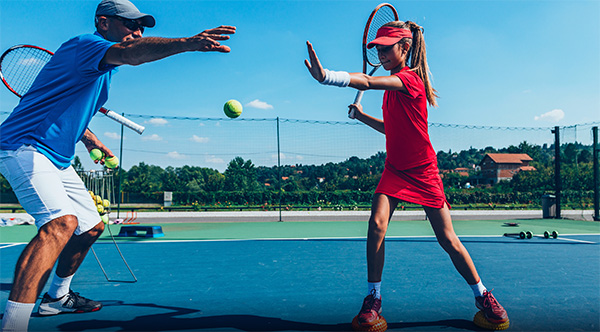 Tennis Kids young girl having a Private Tennis Lesson with a tennis coach